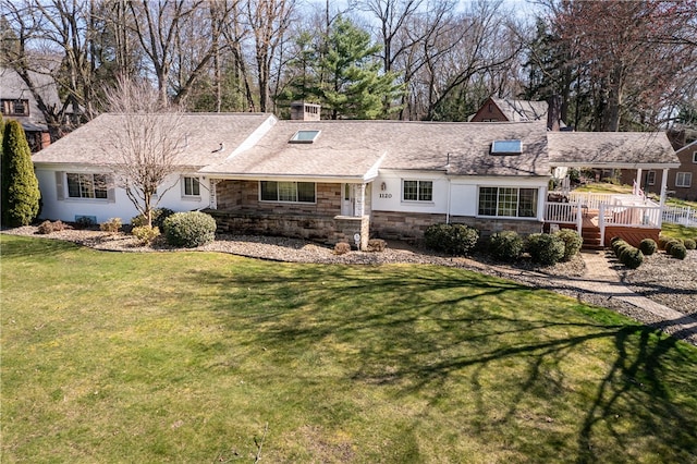 ranch-style home featuring a deck and a front lawn