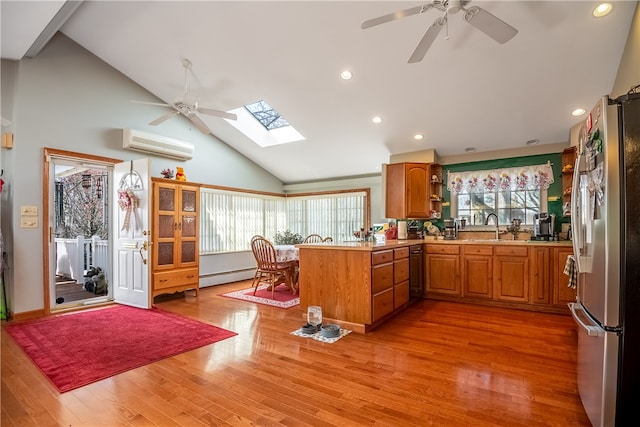 kitchen with hardwood / wood-style floors, a skylight, ceiling fan, stainless steel fridge, and baseboard heating