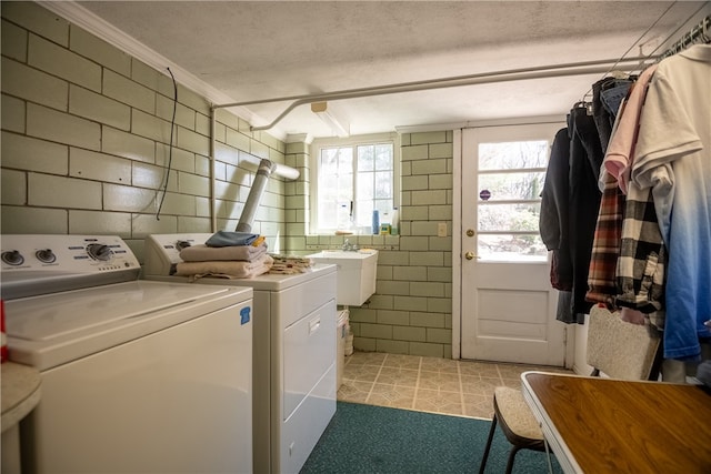 laundry area with light tile flooring, separate washer and dryer, a textured ceiling, and crown molding