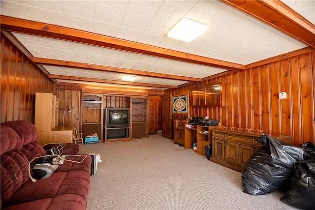 living room featuring wooden walls, beam ceiling, and light carpet