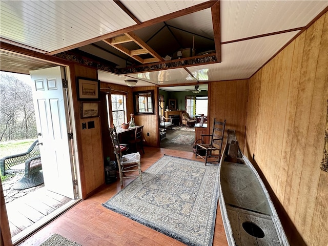 misc room featuring wooden walls, dark hardwood / wood-style floors, and ceiling fan