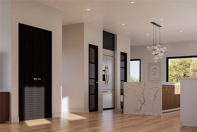 entryway featuring a chandelier and light hardwood / wood-style floors