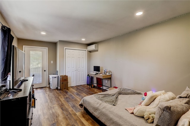 bedroom featuring a closet, access to exterior, a wall mounted AC, and dark wood-type flooring