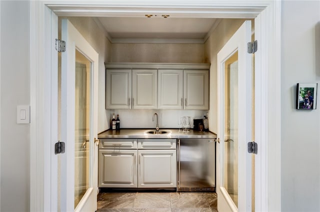 bar featuring sink, fridge, and light tile floors