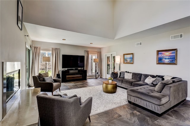 living room featuring a high ceiling and dark tile floors