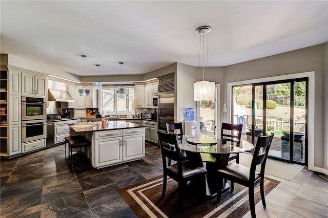 dining room with a healthy amount of sunlight and dark tile floors