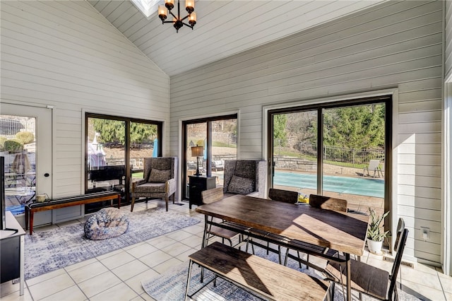 sunroom / solarium featuring a notable chandelier and vaulted ceiling