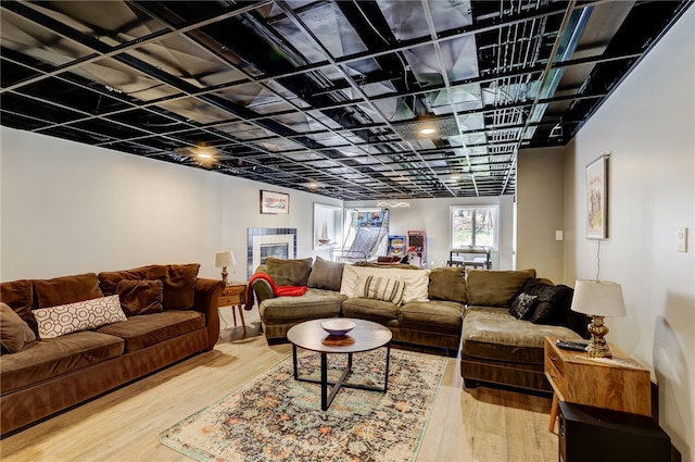 living room featuring a tile fireplace and light hardwood / wood-style floors