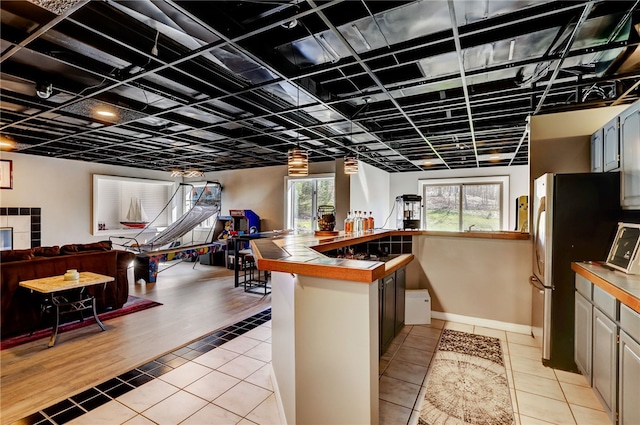 kitchen featuring light hardwood / wood-style floors, stainless steel fridge, and a wealth of natural light