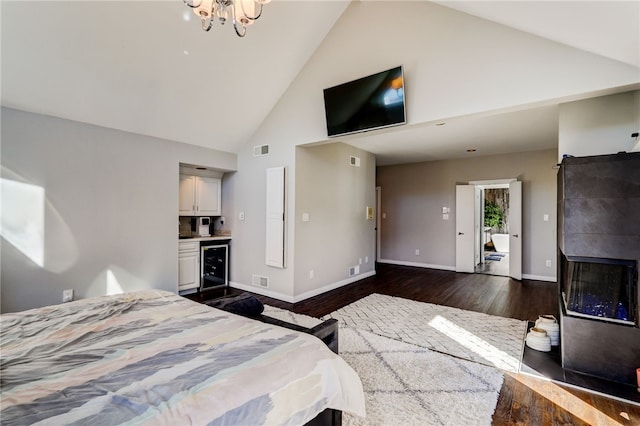 bedroom featuring beverage cooler, dark wood-type flooring, high vaulted ceiling, and a chandelier