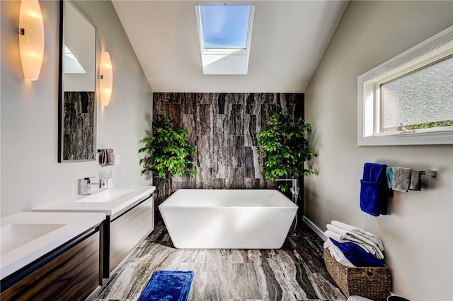 bathroom with a skylight, a washtub, and vanity