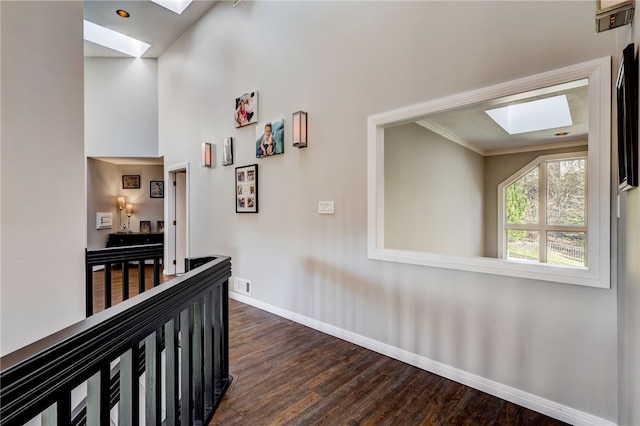 hall with crown molding, a skylight, and dark wood-type flooring