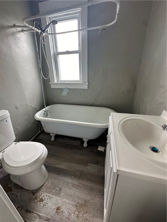 bathroom featuring toilet, vanity, a bathtub, and hardwood / wood-style flooring