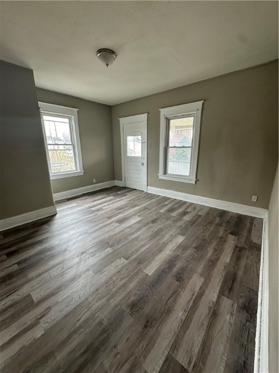 empty room with dark hardwood / wood-style flooring