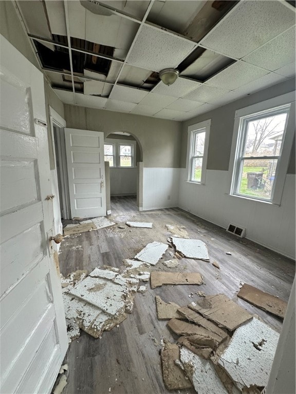 misc room featuring hardwood / wood-style floors, a drop ceiling, and a wealth of natural light