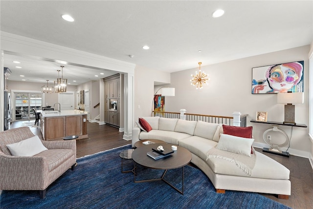 living room featuring dark hardwood / wood-style floors, sink, and a chandelier