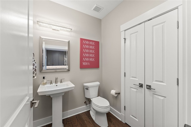 bathroom with hardwood / wood-style floors and toilet