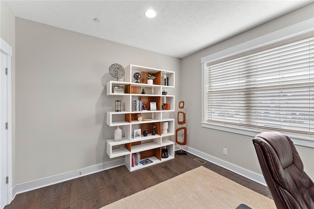 office with dark hardwood / wood-style flooring and a textured ceiling