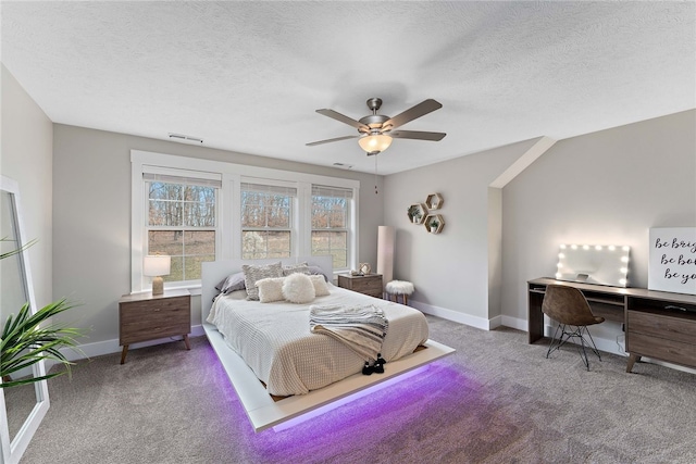 carpeted bedroom featuring ceiling fan and a textured ceiling