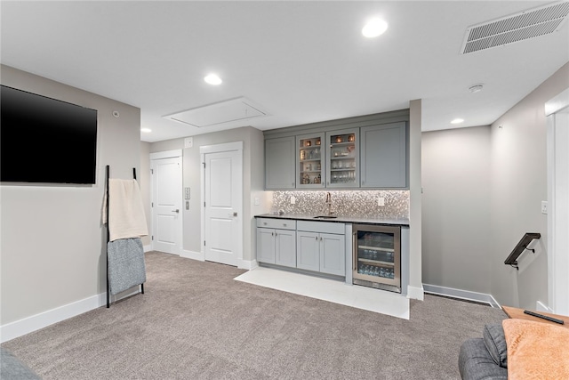 bar with wine cooler, sink, tasteful backsplash, gray cabinets, and carpet floors