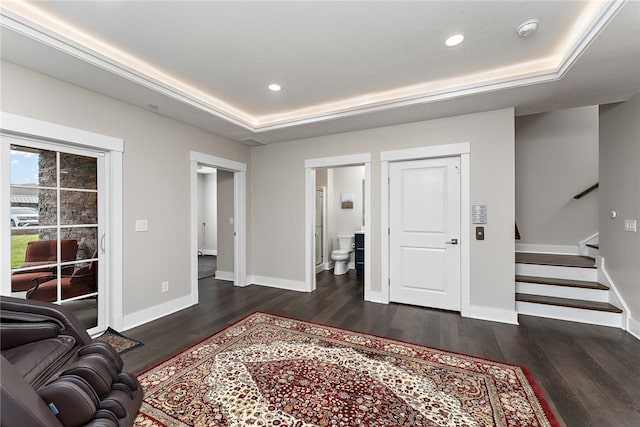 interior space with dark hardwood / wood-style flooring and a tray ceiling