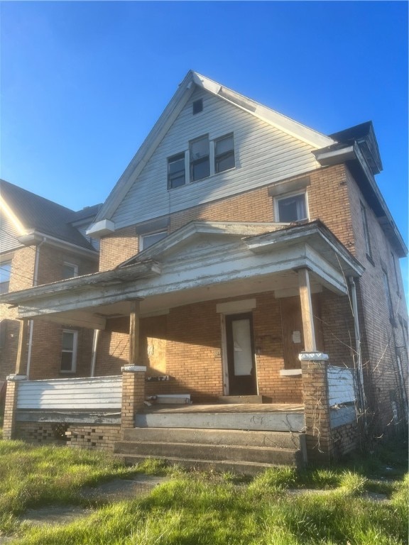 back of property featuring covered porch