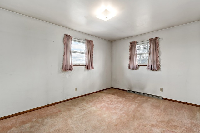 carpeted spare room with baseboard heating and a wealth of natural light