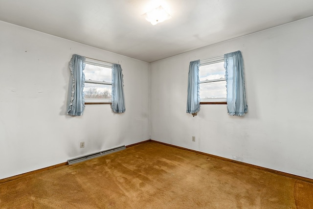 carpeted empty room with a wealth of natural light and a baseboard heating unit