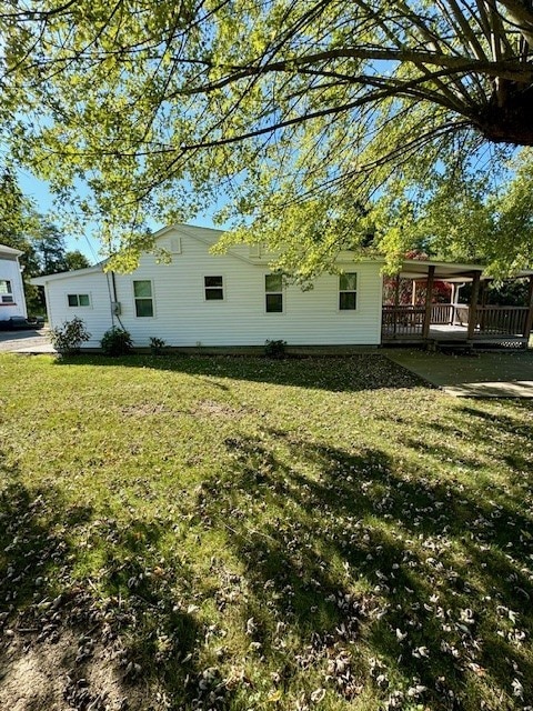 view of property exterior featuring a lawn and a wooden deck