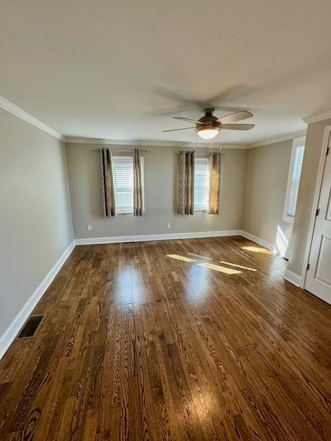 empty room with ceiling fan, crown molding, and dark wood-type flooring