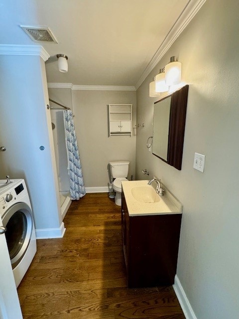 bathroom with vanity, washer / clothes dryer, hardwood / wood-style flooring, walk in shower, and toilet