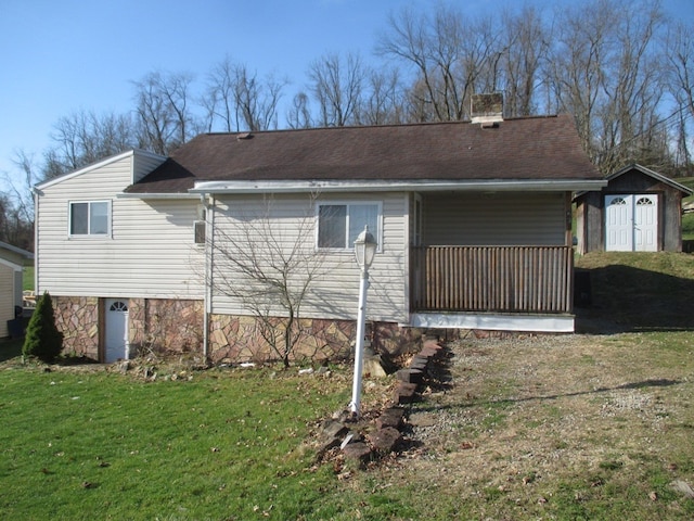 back of property featuring a yard and a storage shed