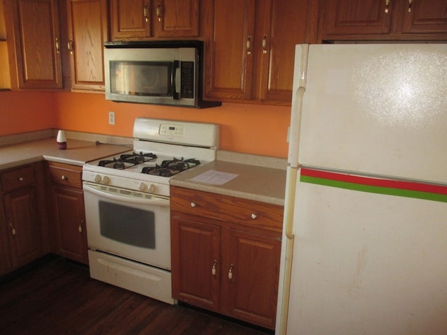 kitchen featuring dark wood-type flooring and white appliances