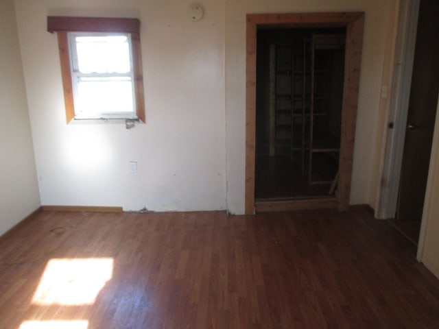 empty room with dark hardwood / wood-style flooring