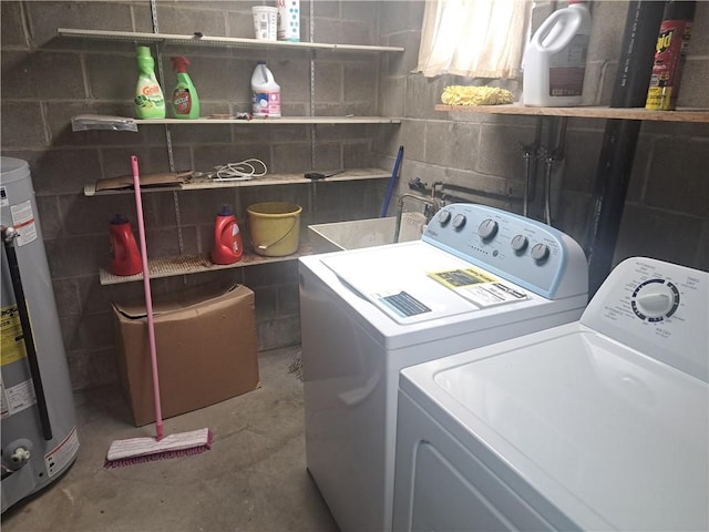 washroom with laundry area, concrete block wall, water heater, and washer and clothes dryer