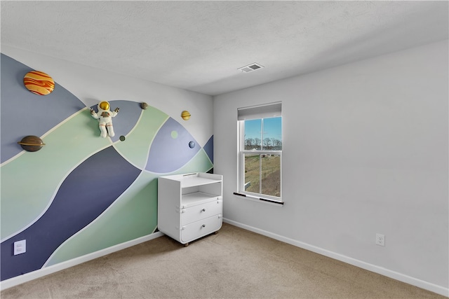 interior space featuring light colored carpet and a textured ceiling