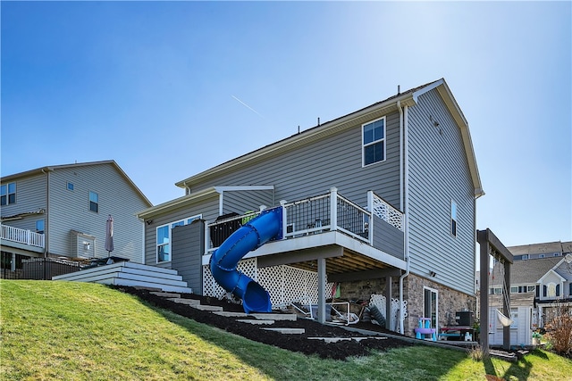 rear view of property with a deck and a lawn