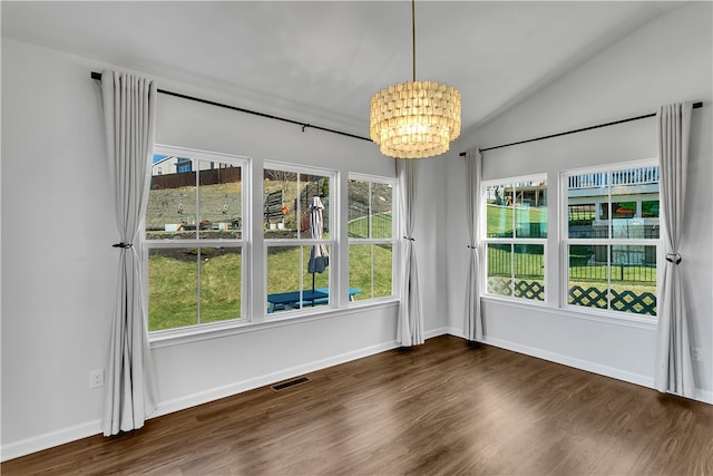 spare room with vaulted ceiling, dark wood-type flooring, and a notable chandelier