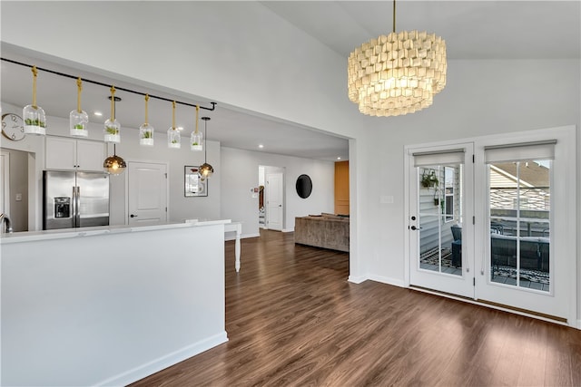 kitchen with stainless steel fridge with ice dispenser, hanging light fixtures, dark wood-type flooring, white cabinetry, and a chandelier