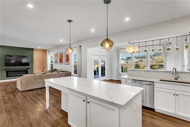 kitchen with white cabinets, sink, decorative light fixtures, and stainless steel dishwasher