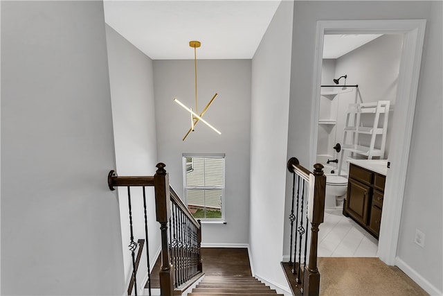 stairs featuring light carpet and an inviting chandelier