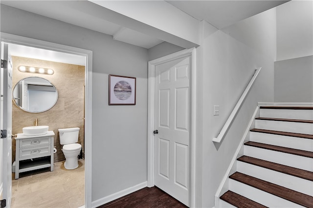 staircase featuring dark hardwood / wood-style flooring and sink