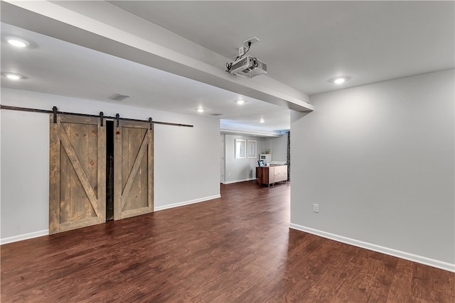 empty room featuring dark hardwood / wood-style floors and a barn door