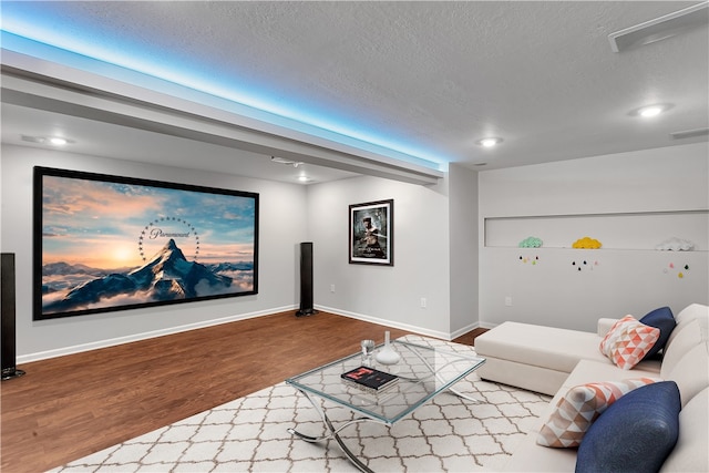 home theater featuring a textured ceiling and light hardwood / wood-style floors