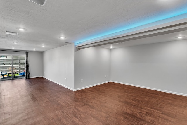 basement featuring dark wood-type flooring and a textured ceiling