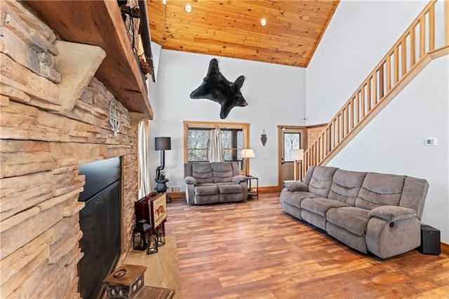 living room with light hardwood / wood-style floors, high vaulted ceiling, wood ceiling, and a fireplace