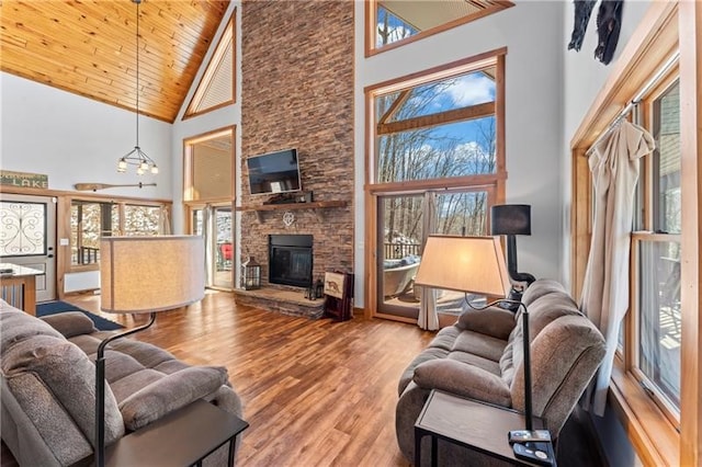 living room with a healthy amount of sunlight, hardwood / wood-style floors, high vaulted ceiling, and wooden ceiling