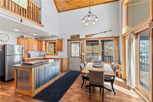 kitchen featuring stainless steel refrigerator, a center island, a chandelier, and wood-type flooring