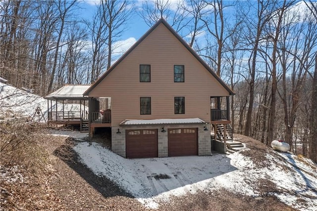 snow covered house featuring a garage