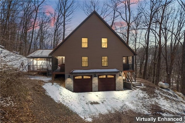 snow covered property with a garage